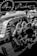 An intricate assembly of metallic gears and mechanical components with detailed reflections on a glossy surface. The scene includes circular cogs and patterns, suggesting a focus on machinery or a mechanical design project.