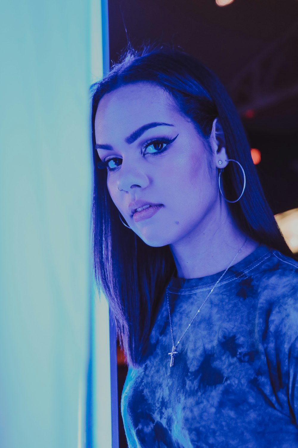 Mujer con camisa floral azul y blanca con auriculares azules