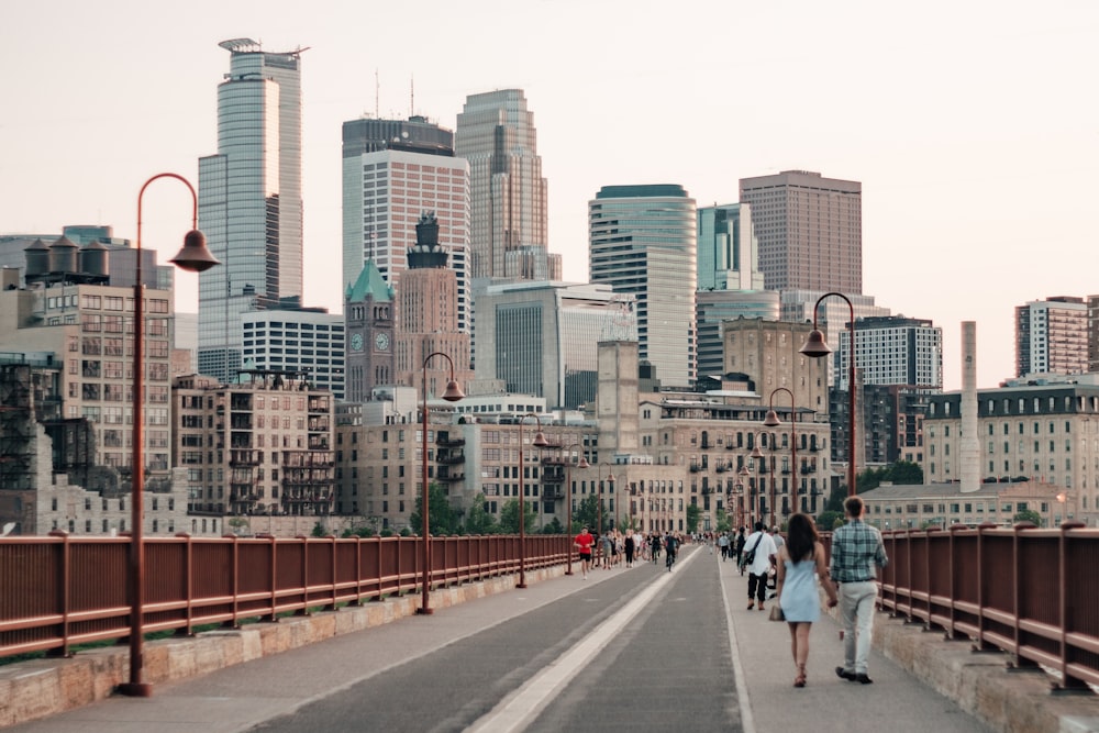 people walking on sidewalk near city buildings during daytime