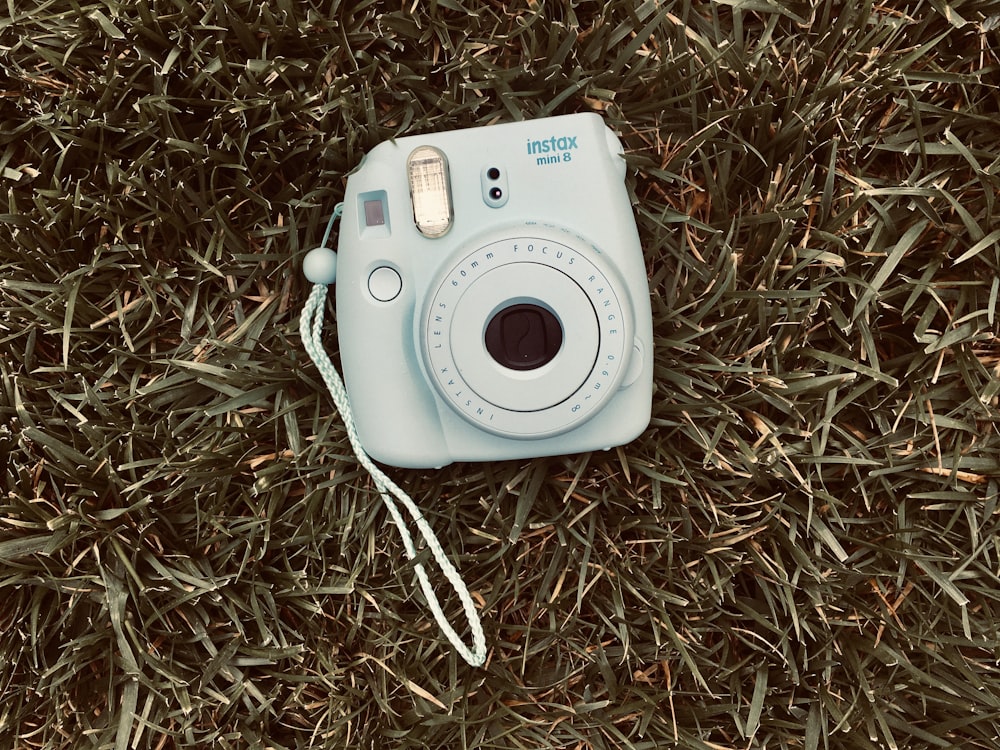white and gray canon camera on brown grass