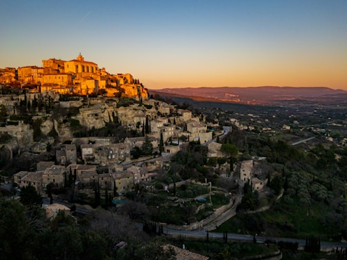 A scenic view of a charming French village with cobblestone streets and colorful houses at sunset.