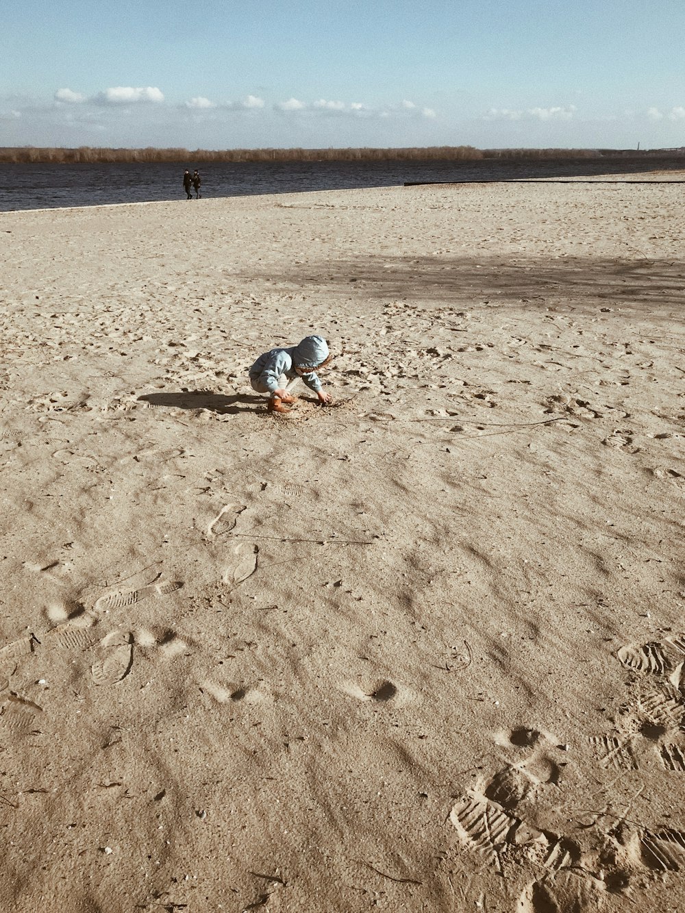 person in blue denim jeans walking on brown sand during daytime