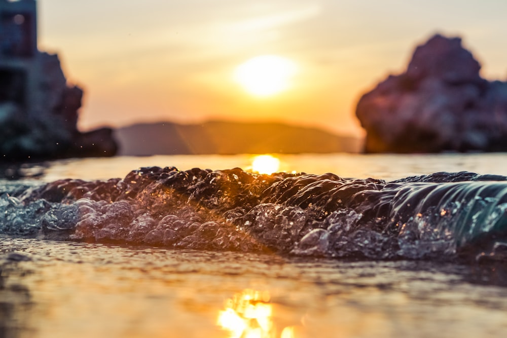 Wasserspritzer auf Brown Rock während des Sonnenuntergangs