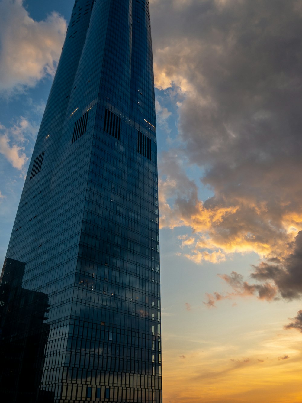 Edificio gris de gran altura bajo nubes grises durante el día