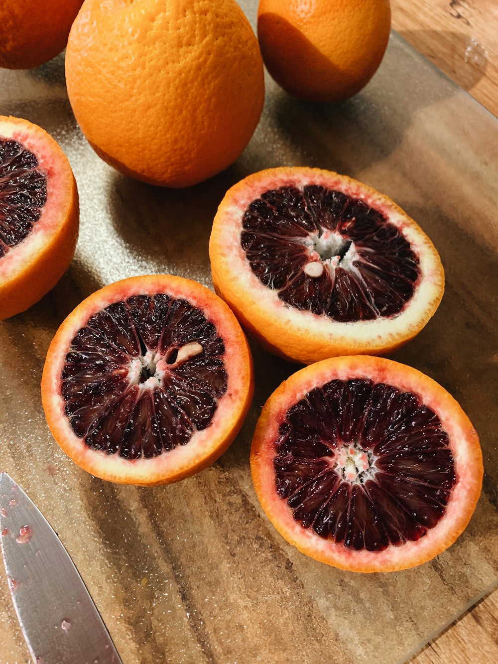 sliced orange fruit on brown wooden chopping board