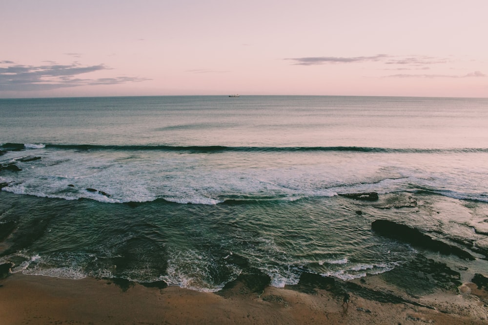 ocean waves crashing on shore during daytime