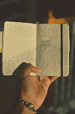 person holding white printer paper with drawing