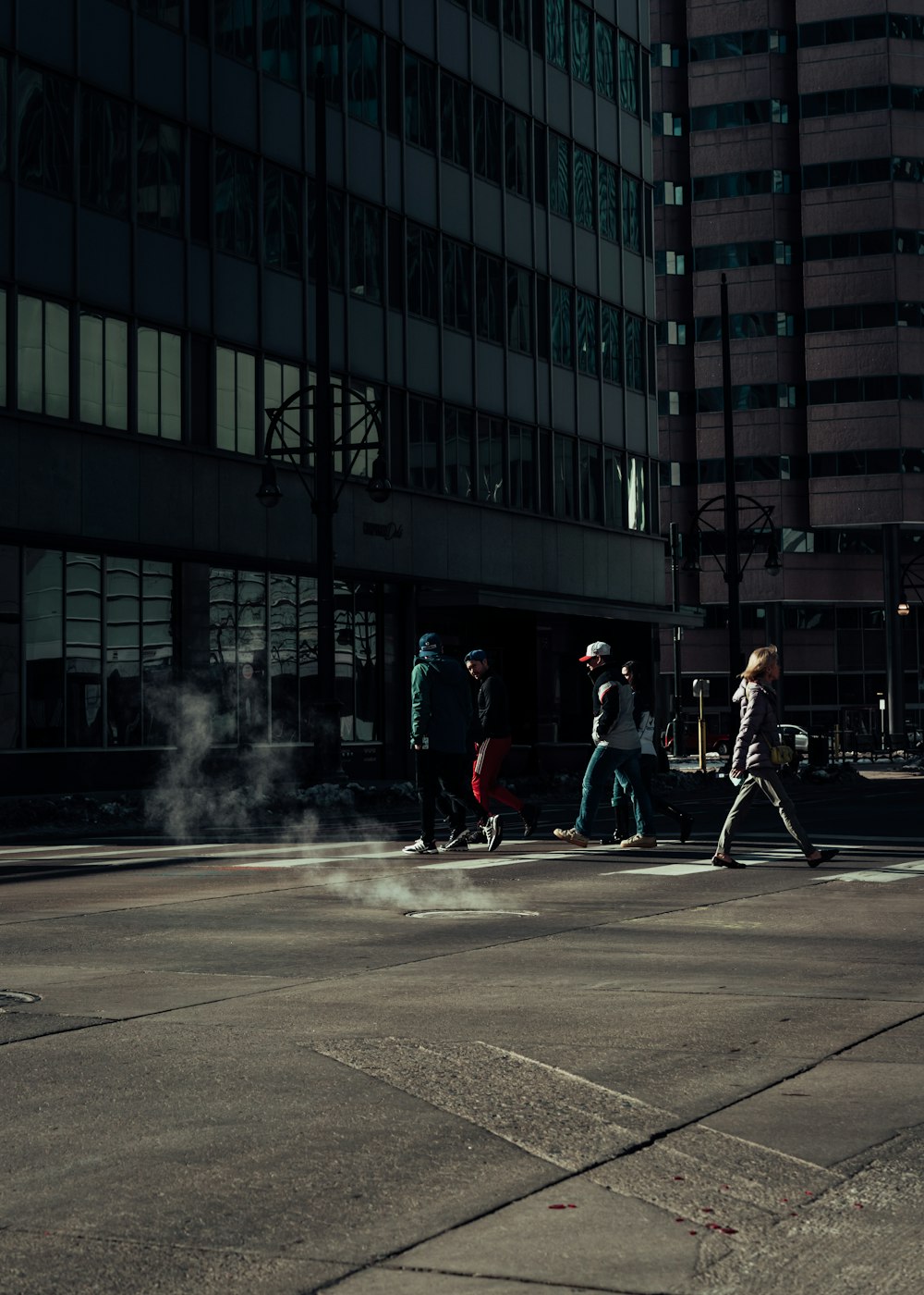 man in red jacket and black pants standing on road with smoke