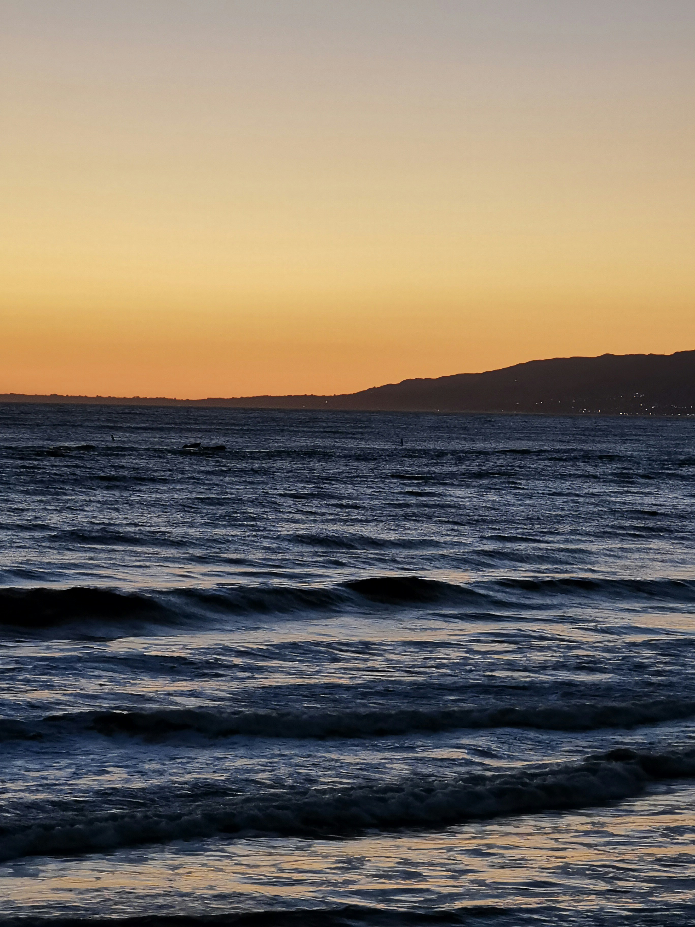 Olas del océano rompiendo en la costa durante la puesta de sol