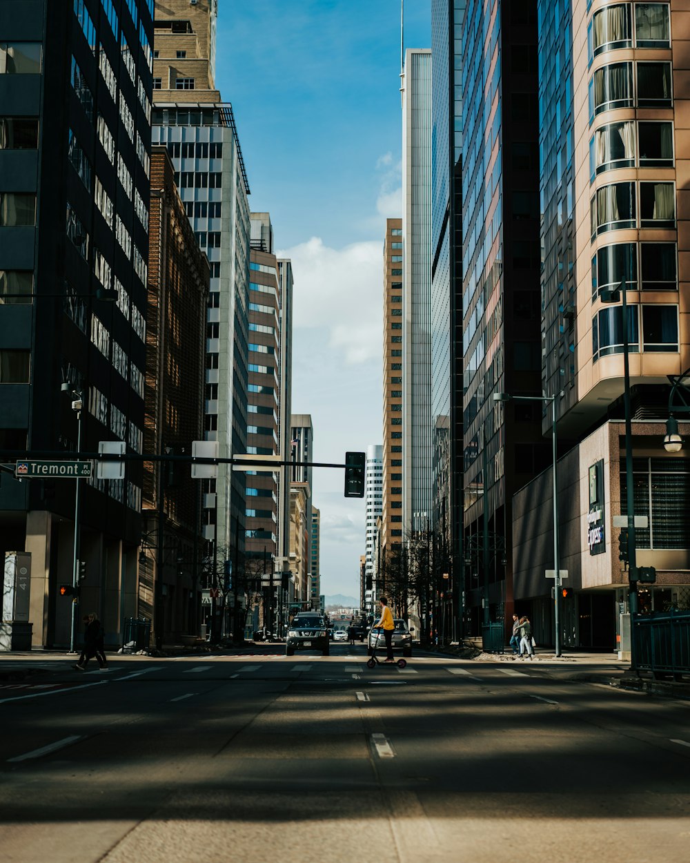 cars on road between high rise buildings during daytime