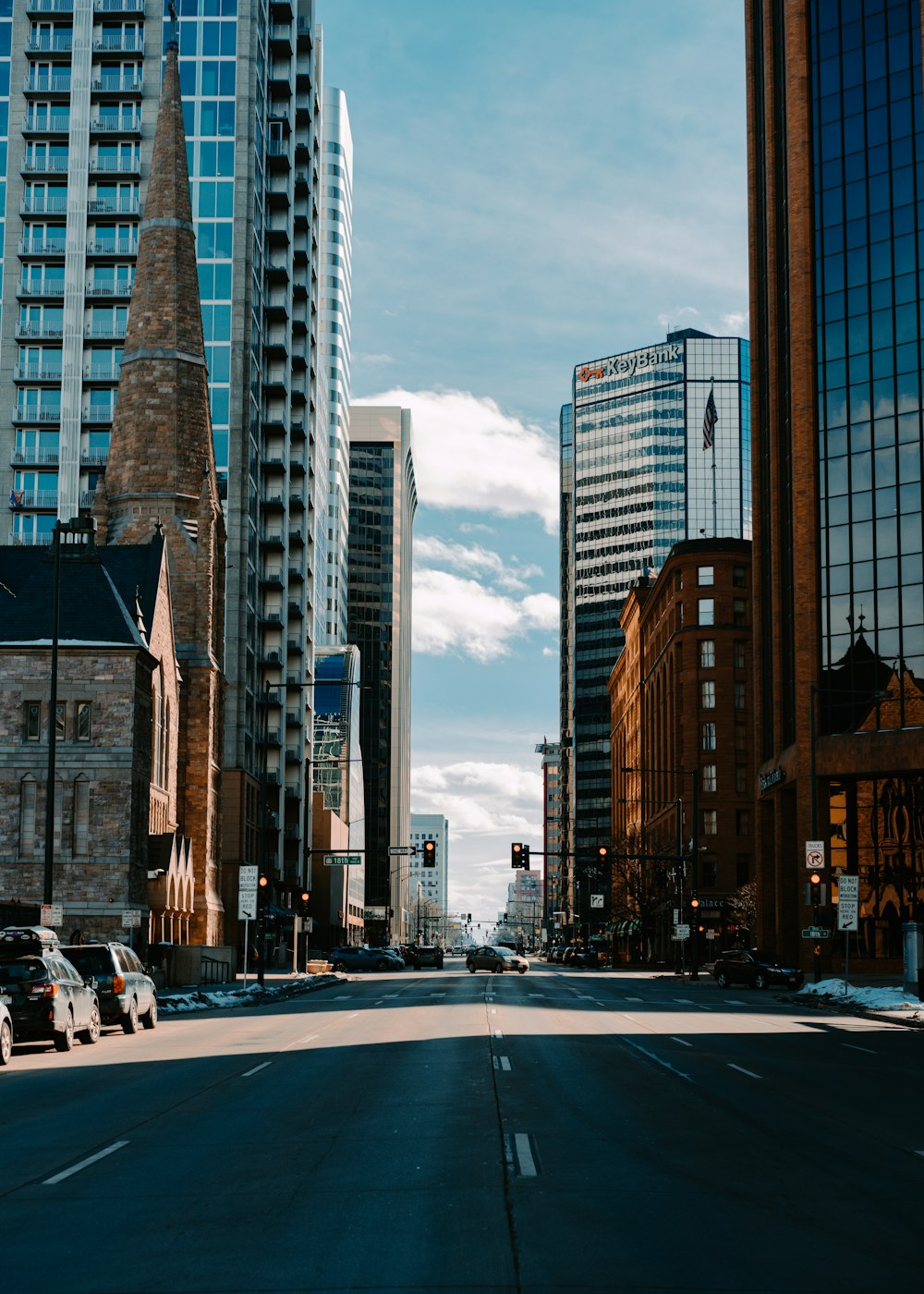 cars on road between high rise buildings during daytime