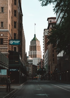 cars on road between high rise buildings during daytime