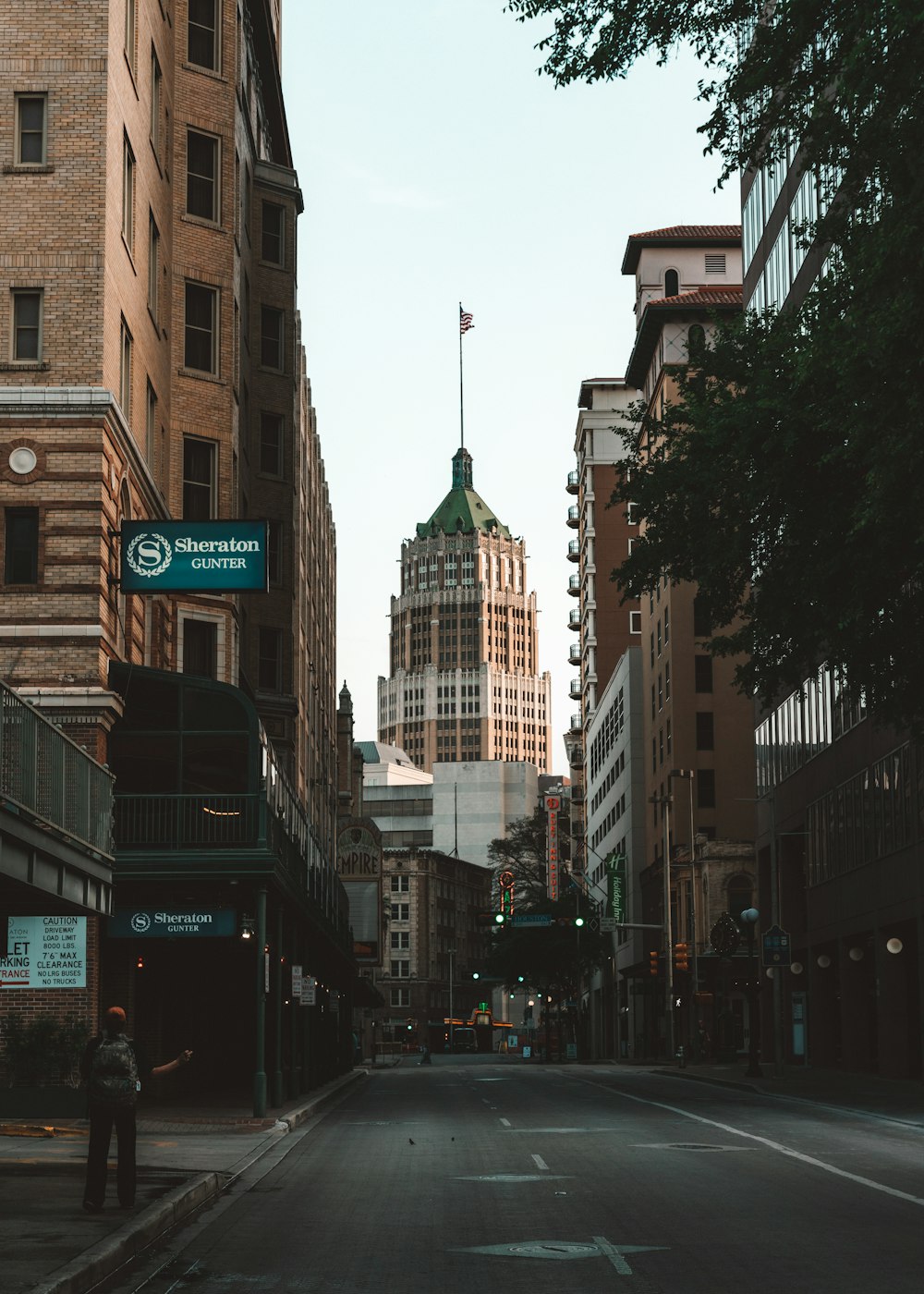 cars on road between high rise buildings during daytime