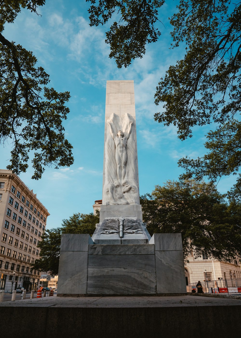 gray concrete statue near green trees during daytime