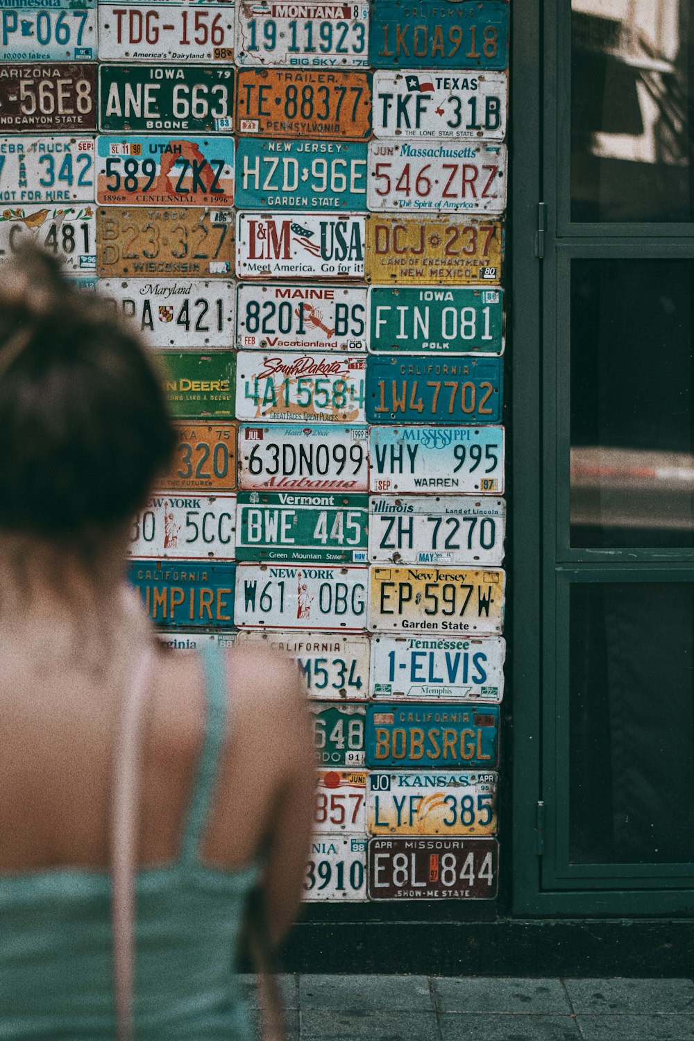 woman in white tank top standing in front of store