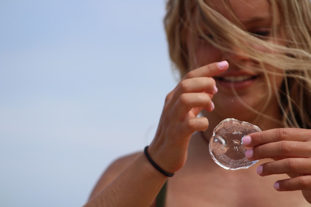 woman in black tank top holding clear glass ball