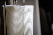 Close-up of a sleek countertop paper towel holder next to fresh ingredients