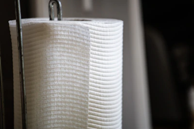 Stack of soft, white disposable paper towels with a subtle texture visible