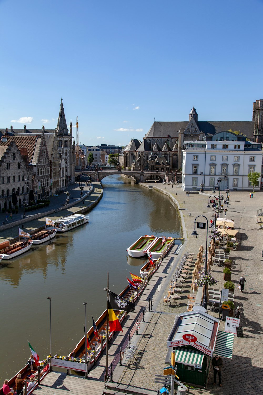 white and brown boat on river near concrete building during daytime