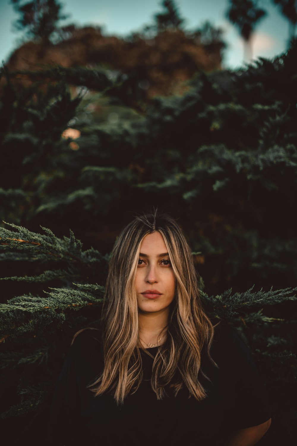 woman in black shirt standing near tree