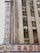 A tall building is partially visible, featuring a vertical neon sign with the words 'Radio City' prominently displayed. Below, another sign reads 'Music Hall' with the text 'Radio City' running horizontally across a marquee. The building exterior is composed of concrete and glass windows.