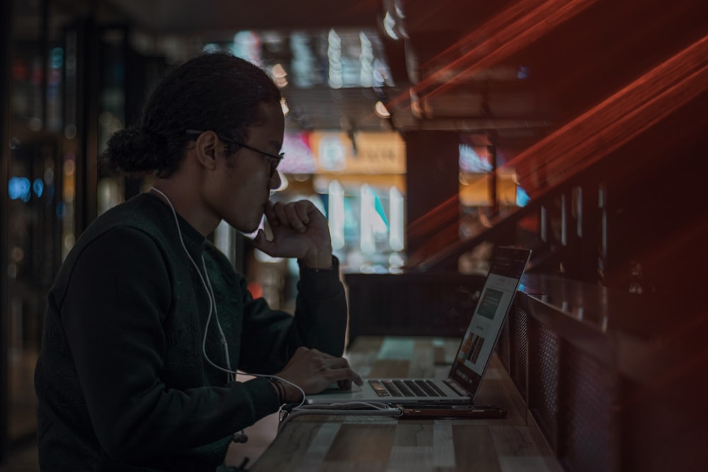 man in black jacket using laptop computer