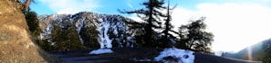 Panoramic view from Engineer Pass showing snow-capped peaks and a convoy of 4x4 vehicles.