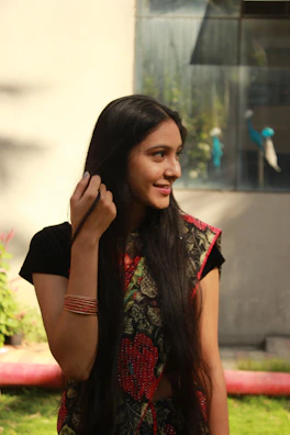 Lifestyle shot of a person wearing a vibrant handblock-printed t-shirt in a sunlit courtyard.