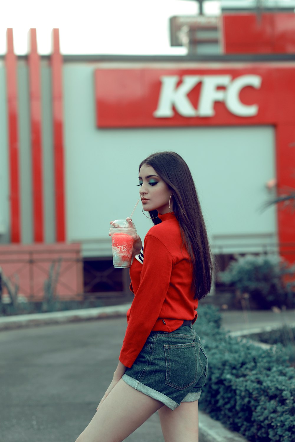 woman in red long sleeve shirt holding clear plastic cup