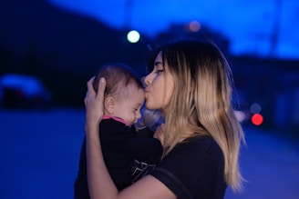woman in black shirt kissing womans cheek