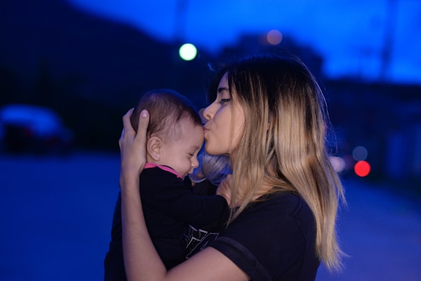woman in black shirt kissing womans cheek