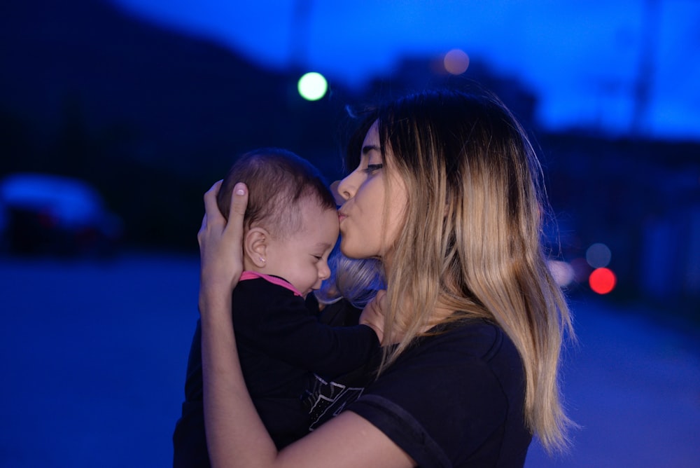 woman in black shirt kissing womans cheek