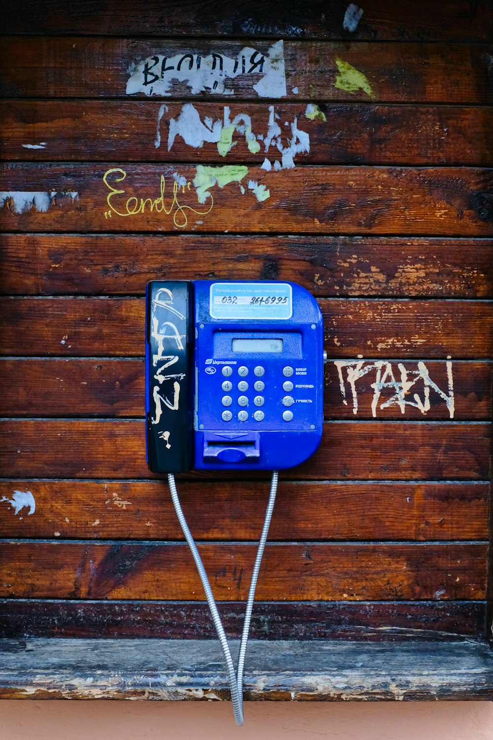 갈색 나무 벽에 파란 전화기
