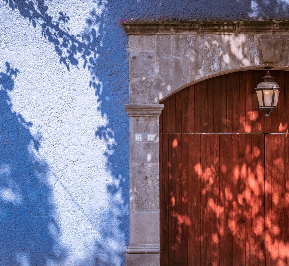 Porta di legno marrone su parete blu e bianca