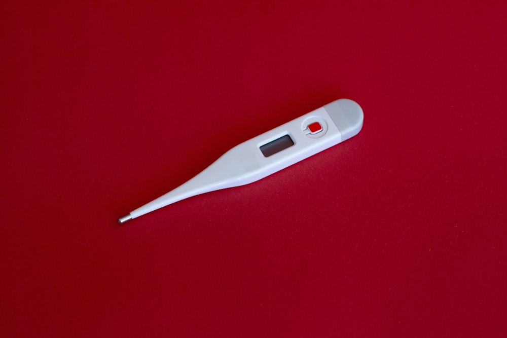 white thermometer on red surface