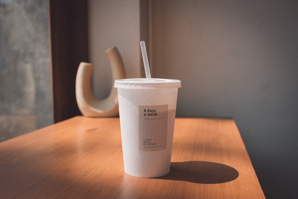 white plastic cup on brown wooden table