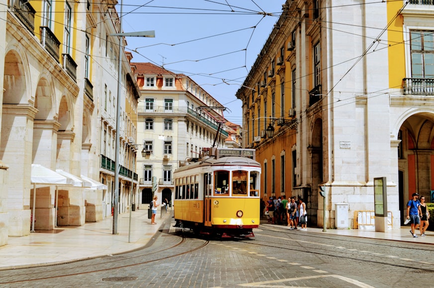 Un tram attraversa le strade di Lisbona di giorno