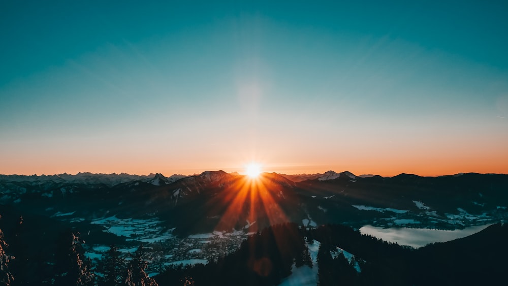 corpo de água perto da montanha durante o nascer do sol