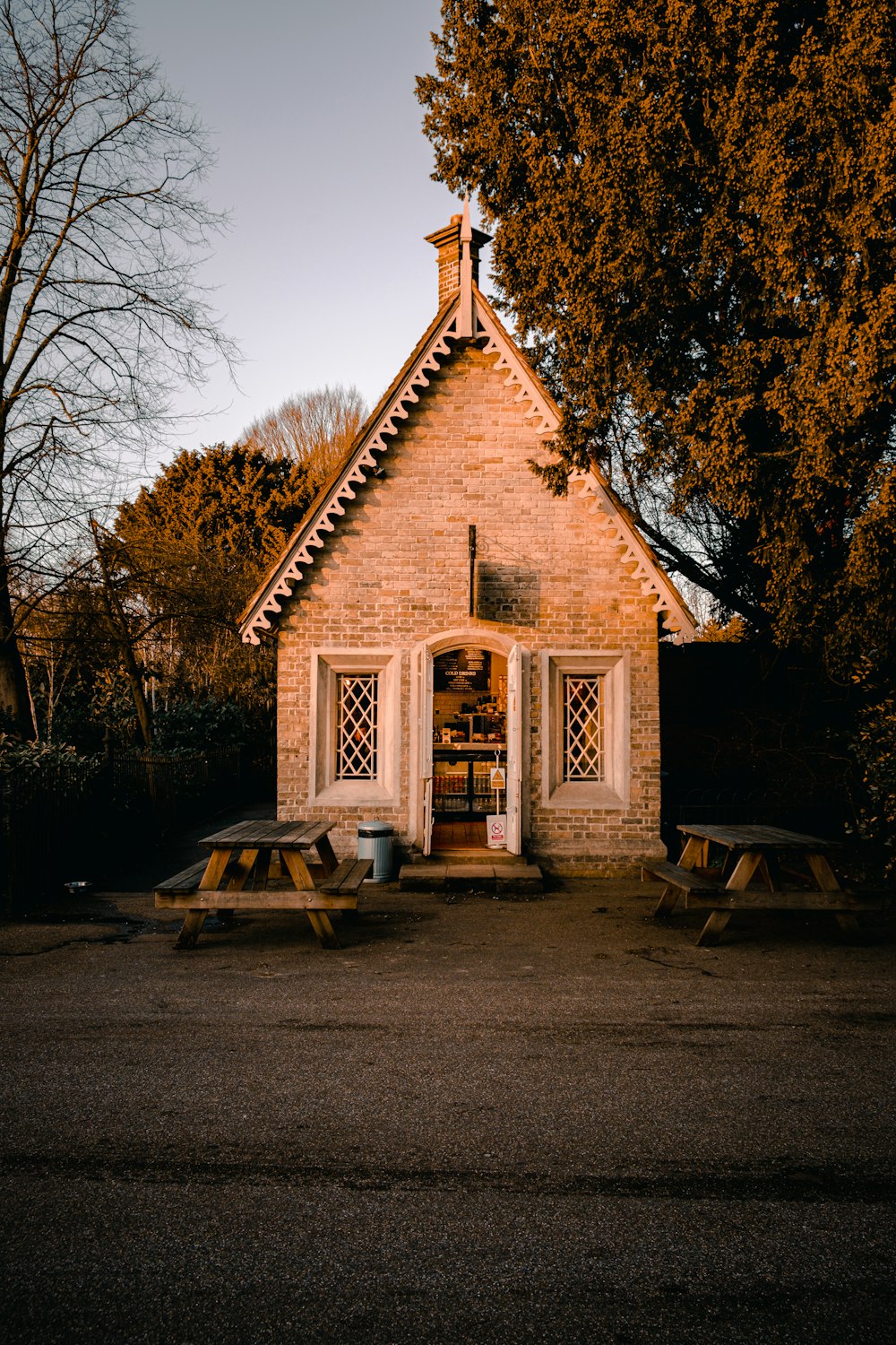 brown and white wooden house near bare trees during daytime