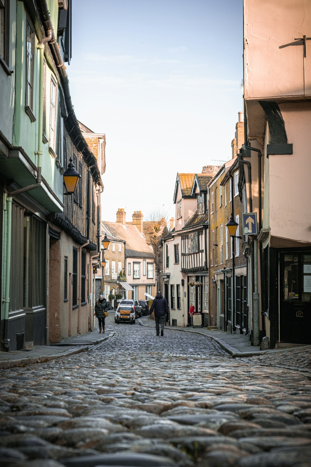 persone che camminano per strada tra gli edifici durante il giorno