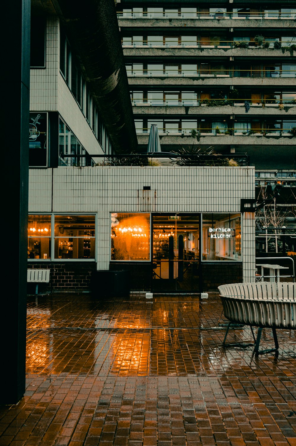 white and black bench near glass wall building during night time