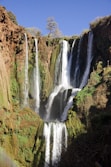 waterfalls in the middle of the forest during daytime