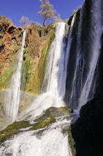 waterfalls on brown rocky mountain during daytime