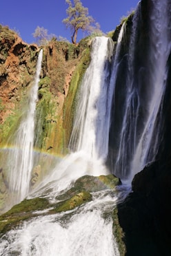 waterfalls on brown rocky mountain during daytime