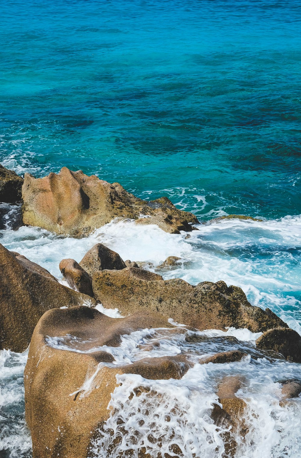 brown rock formation near body of water during daytime