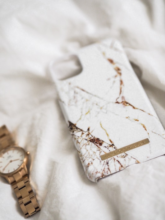 Close-up of a sleek iPhone case with a vibrant marble pattern on a wooden table.