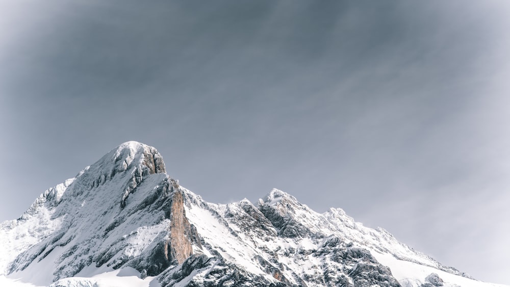 snow covered mountain under cloudy sky during daytime