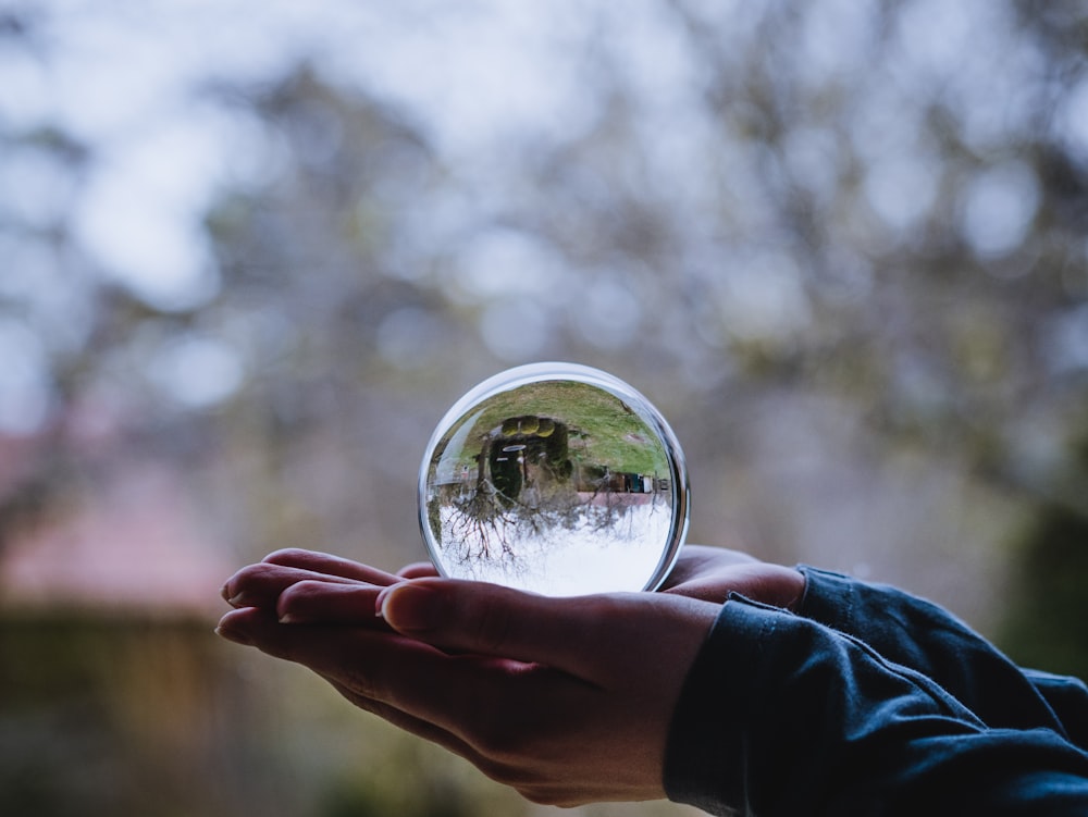 person holding clear glass ball