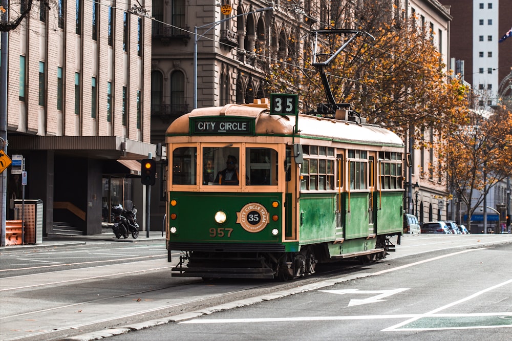 green and yellow tram on road during daytime