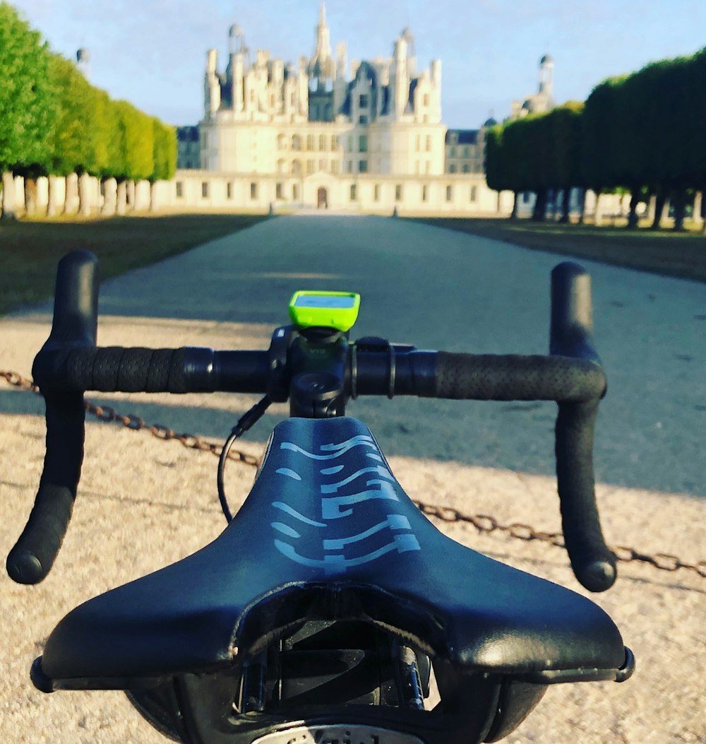 Bicicletta blu e nera sulla strada di cemento grigia durante il giorno